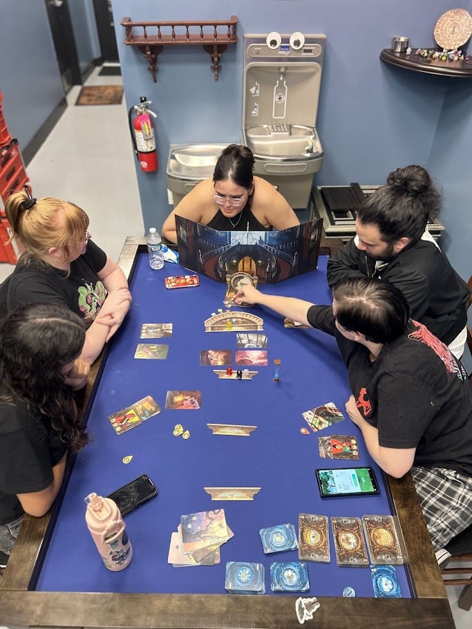 Group of players gathered around a tabletop game at Skillshotz Gaming in Deerfield Beach South Florida